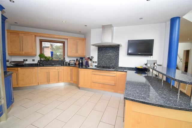 Much of the ground floor is an open-plan family area, including this designer bespoke kitchen. It features a range of base and wall units in solid maple wood, with granite worktops, an inset stainless-steel sink and five-ring gas-burner with extractor hood.