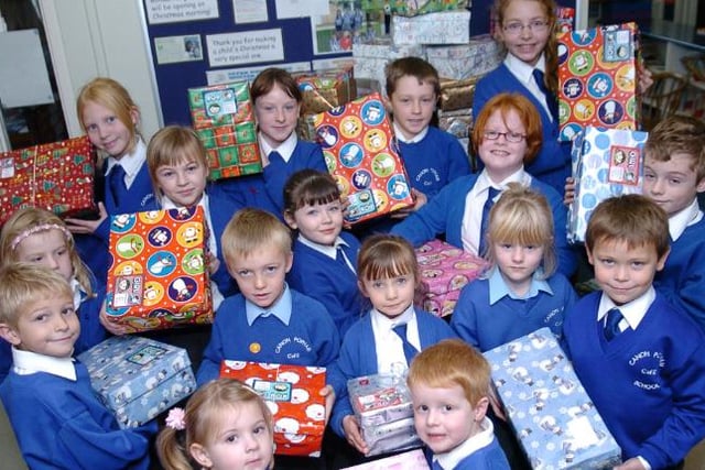 Children at Canon Popham Primary School in 2007 holding Christmas presents.