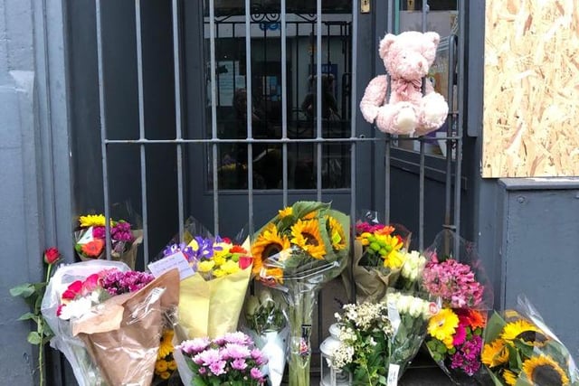 A teddy bear was left in addition to the many flowers that had been laid