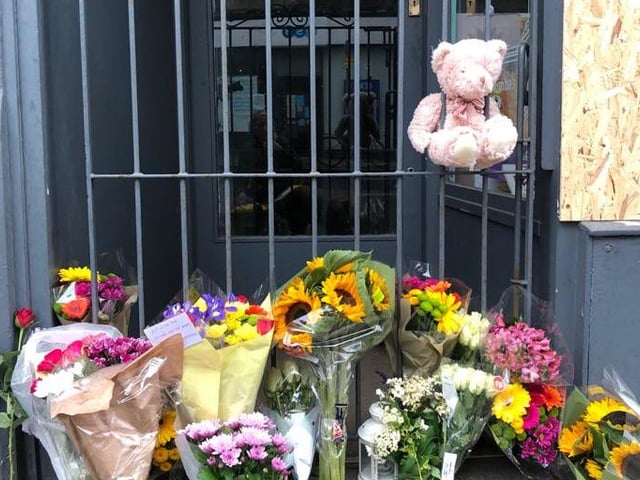A teddy bear was left in addition to the many flowers that had been laid