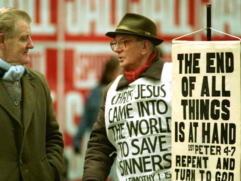 A street evangelist tries to persuade a passer-by that 'The End of All Things is At Hand' in Argyle Street during the Boxing Day sales in Glasgow, December 1992.