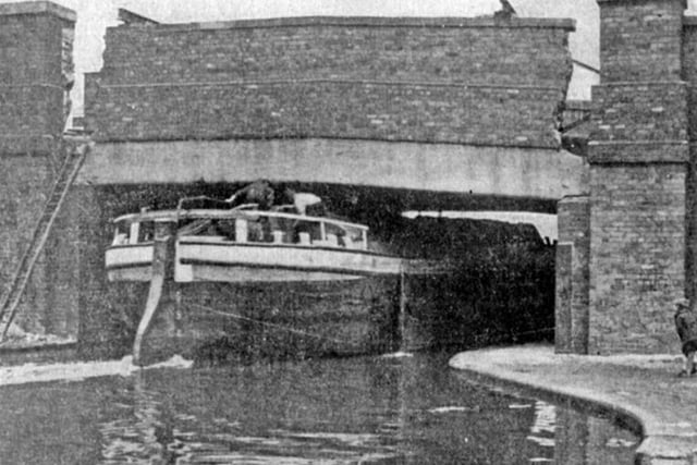 A boat squeezes its way under Broughton Lane Bridge on the canal in Sheffield