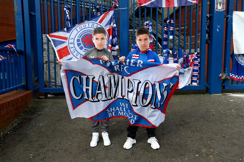Rangers fans wearing Steven Gerrard masks hold up a banner outside of the Ibrox Stadium, home of Rangers FC.