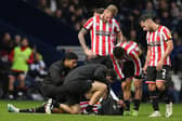 Sheffield United's Rhian Brewster receives treatment on the pitch for his injury: Andrew Yates / Sportimage