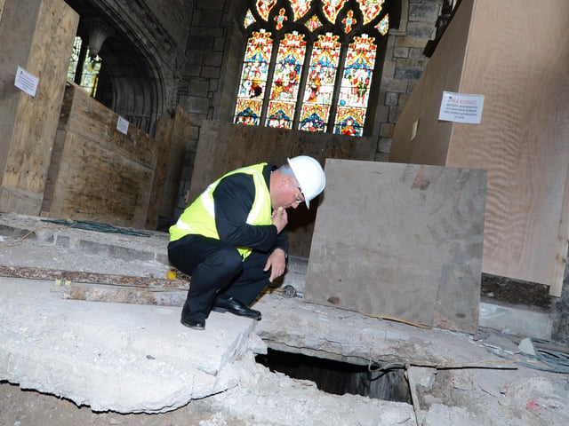 A university is trying to help unravel a centuries-old mystery after it was revealed 15 bodies have disappeared from the burial crypt of an important family - including three Earls of Shrewsbury. Workmen at Sheffield Cathedral discovered the historical mystery when they stumbled across the entrance to Shrewsbury tomb - only to find just two coffins inside.
At least 17 members of the Shrewsbury family, who were the Lords of Sheffield Manor for generations, were laid to rest beneath the 500-year-old chapel and are now missing.
Canon Simon Cowling looks down into the crypt which has been discovered at Sheffield Cathedral in 2013.
