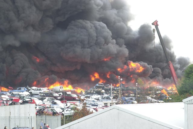 Cars are piled up in Noble's scrapyard at Randolph Industrial Estate in November 2002 as thick smoke billows above (Pic: Fife Free Press)