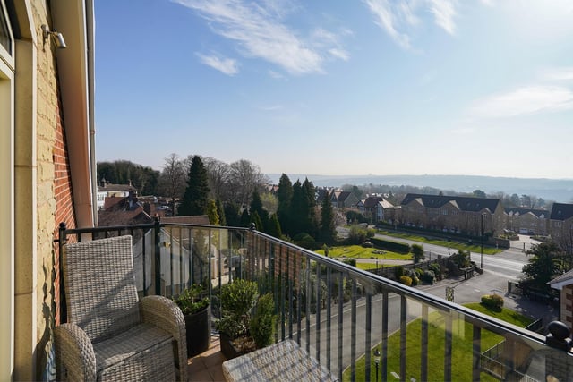 The balcony overlooks the immaculately presented grounds with lawns and seating areas for residents.