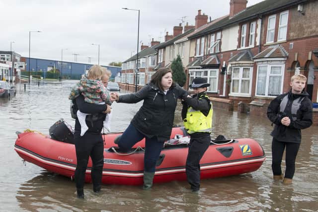 A woman being rescued after being taken from her home as waters rose in the floods