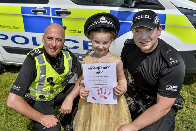 Sophia Green (5) from Carron shows off her finger prints with commumity police officers Sergeant Mark Armstrong (left) and PC Chris Morrison (right)