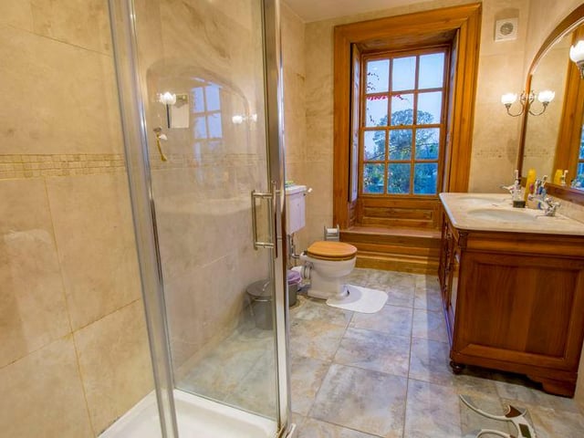This bathroom has two sinks and a shower.
