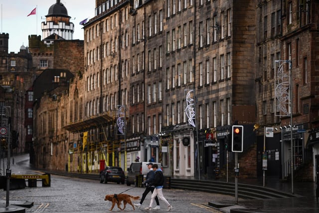 Members of the public walk through a deserted Edinburgh City Centre