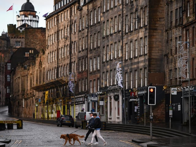 Members of the public walk through a deserted Edinburgh City Centre