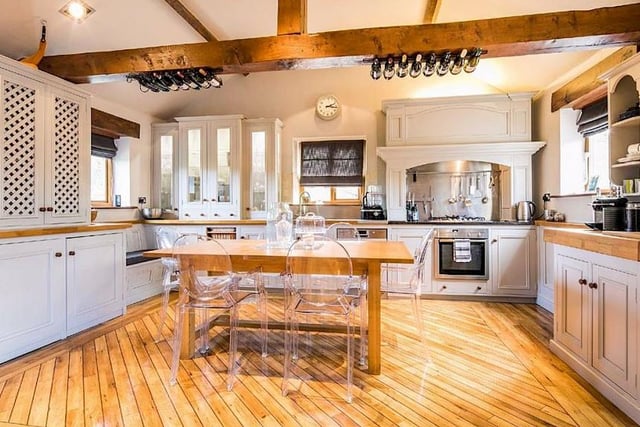 The impressive, hand-painted kitchen offers access through to the dining space/snug - note the wine bottles arranged on the central timber beam.