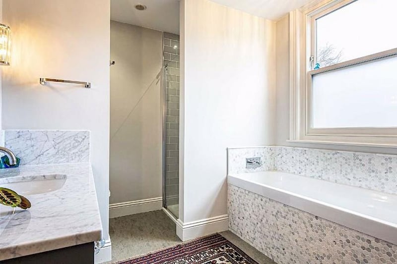 The family bathroom has a marble-topped sink and a separate shower enclosure beyond the bath.