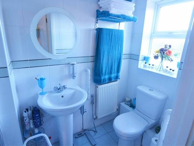 This the en suite to the second bedroom. A step-in shower enclosure is complemented by a wash hand basin and push-button WC.