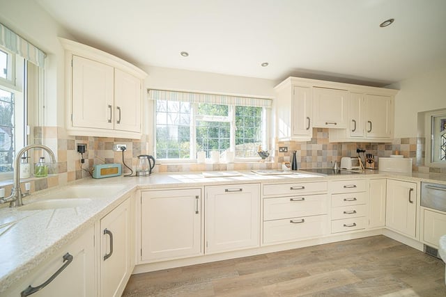 The cottage kitchen is light and airy, and features a wealth of fitted storage units and integrated appliances.
