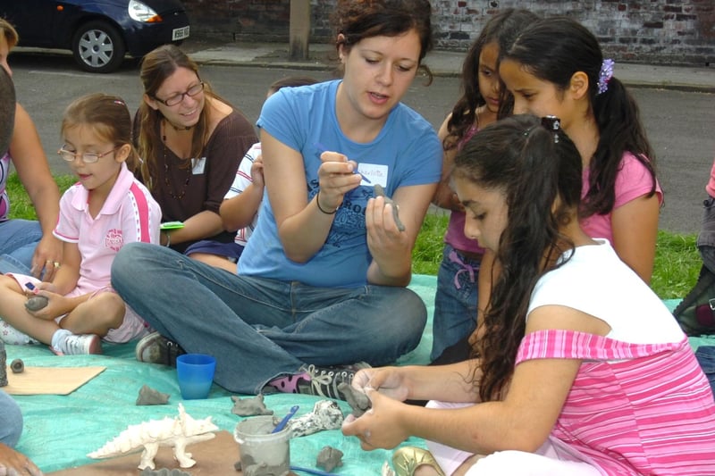 Children and volunteers working to make clay models from Jurassic Park at a summer Art in the Park event held at the Philadelphia Green Space, Fox Road, Upperthorpe, Sheffield