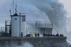 Waves crash against the harbour wall during storm Eunice in Porthcawl, Wales.