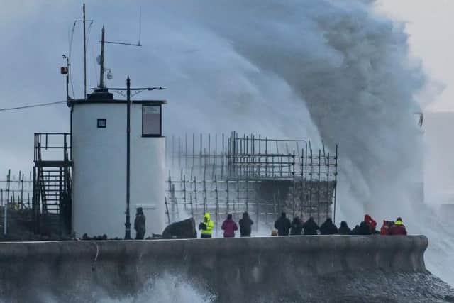Waves crash against the harbour wall during storm Eunice in Porthcawl, Wales.
