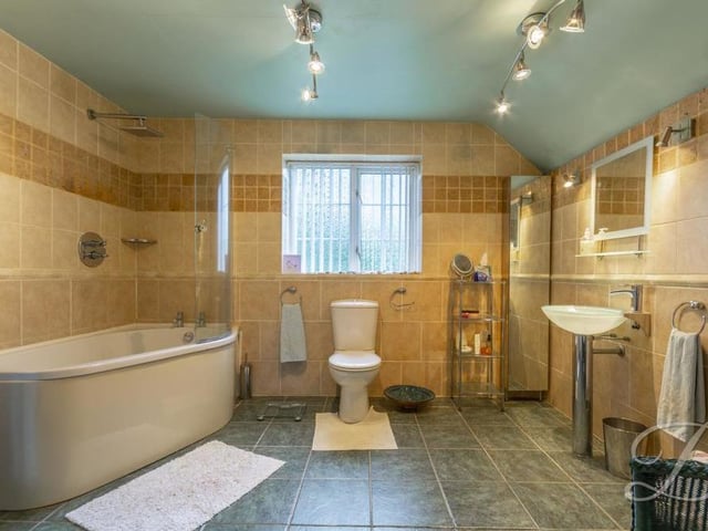 This en suite to the main bedroom is big and bright. It comprises a bath, low-flush WC, wash hand basin, cupboard for storage and an opaque window to the back.