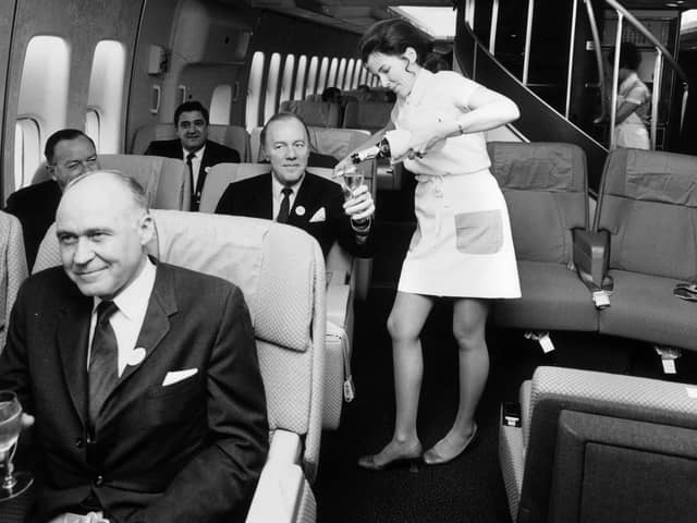 A Pan American (Pan Am) airhostess serving champagne in the first class cabin of a Boeing 747 jumbo jet.   (Photo by Tim Graham/Getty Images)