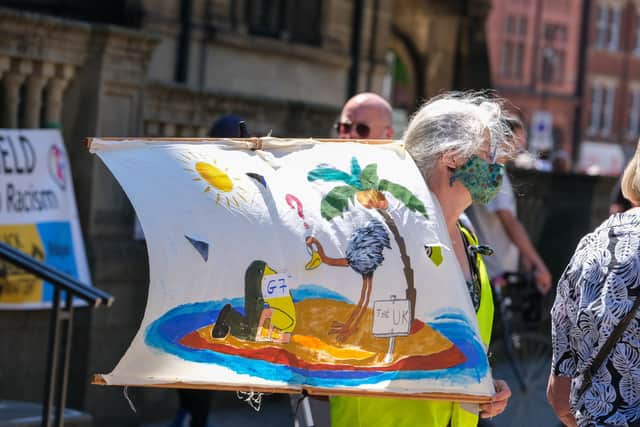 A banner commenting on world leaders' responses to climate change at a Sheffield Town Hall protest timed to coincide with the G7 talks in Cornwall