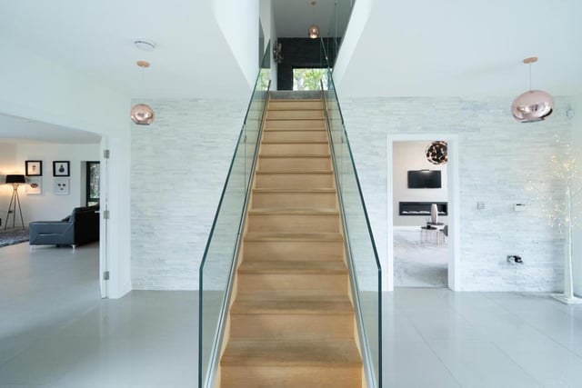 An impressive staircase with glass sides leads to the bedrooms. 
Image by Rightmove.