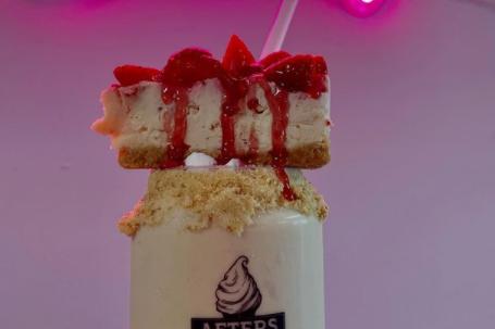This milkshake has a whole piece of cheesecake on top.
