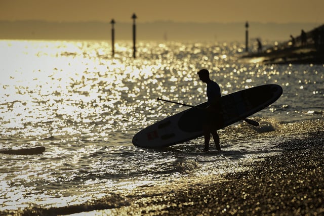 A stand up boarder enters the sea in the evening sunshine on Southsea beach taken by Finnbarr Webster/Getty Images.