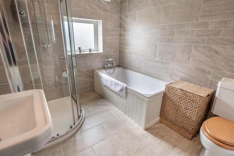 This modern bathroom features a walk-in shower and is beautifully tiled.