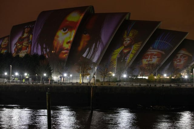 Faces of indigenous peoples appear during the projection of #ProjectingChange onto the exterior of SEC Armadillo