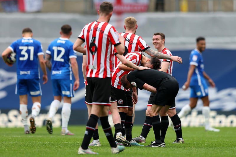 Referee David Webb is consoled by players of Sheffield United after being hit by a ball (Matthew Lewis/Getty Images)