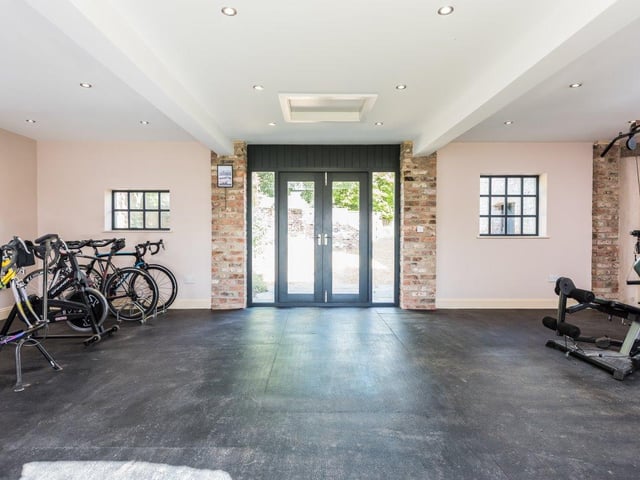 The large gymnasium boasts enough space to accommodate a number of exercise machines and gym equipment, and opens out onto the grounds.
