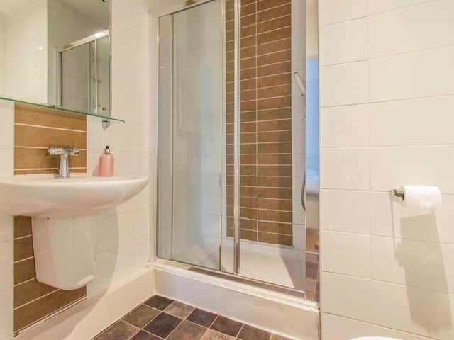En-Suite Shower Room  - Fitted with a low flush WC, a wash hand basin with mixer tap and a thermostatic shower. There is tiling to the walls and floor, an extractor fan and spotlights to the ceiling.
