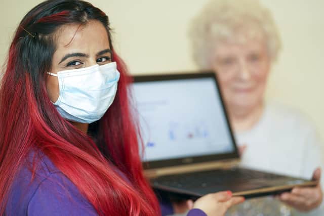 Support worker Rehneesa Inez makes a charity laptop presentation to 'Linda', a vulnerable Sheffield pensioner.
