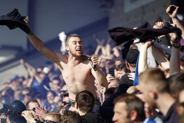 A Pompey fan takes off his shirt amid the celebrations