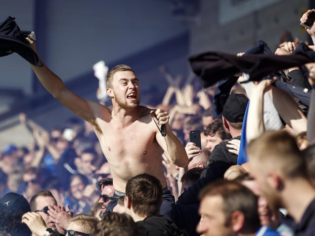 A Pompey fan takes off his shirt amid the celebrations