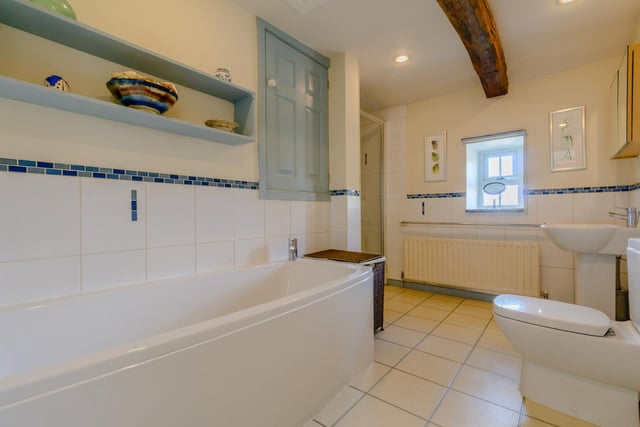 The main bathroom includes a modern four piece suite comprising a low flush W.C, a pedestal wash hand basin, a step-in shower and a panelled bath. The room also has an
exposed beam to the ceiling, an Amtico floor and half tiling to the walls.