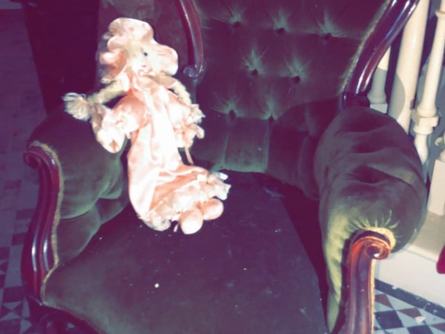 What's a creepy mansion without an abandoned doll? This one lies abandoned on a plush velvet chair. Who did it belong to?