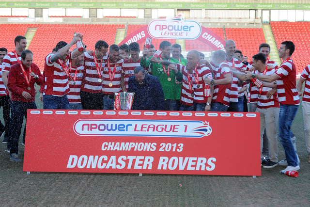 Champagne is sprayed as the Rovers squad receive the League One trophy