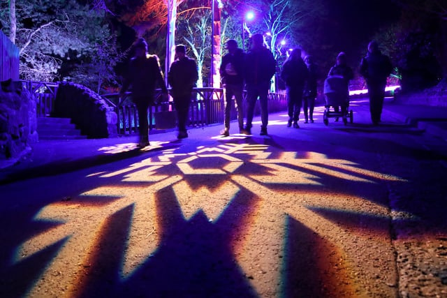 Members of the public walk through snowflakes projected onto paths at the launch of Edinburgh Zoo's Christmas Nights.