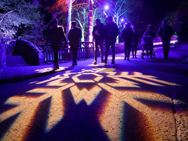 Members of the public walk through snowflakes projected onto paths at the launch of Edinburgh Zoo's Christmas Nights.
