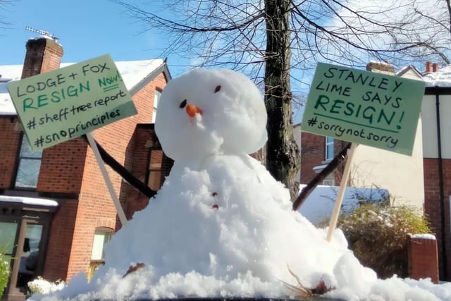 A snowman with a placard next to the Stanley lime tree