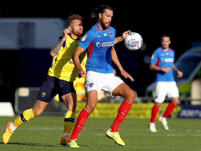 Christian Burgess holds off Matty Taylor of Oxford United.