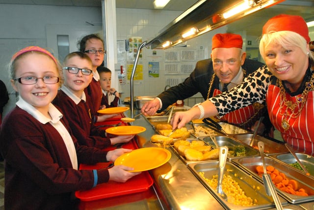 The Mayor and Mayoress take time out to serve the children at Holy Trinity School in this 2014 dinnertime session.