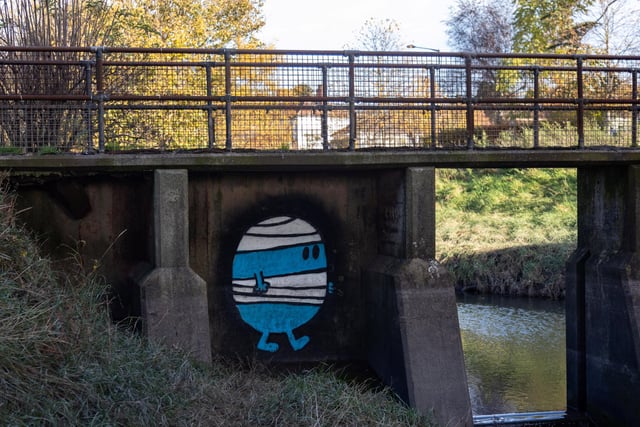 Mr Bump is under a footbridge over the River Trym and can be seen from Sea Mills railway station