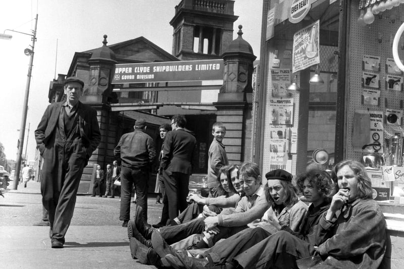 Shipyard workers eat their lunch in the sunshine outside the gates of the Govan division of the Upper Clyde Shipbuilders in June 1971.