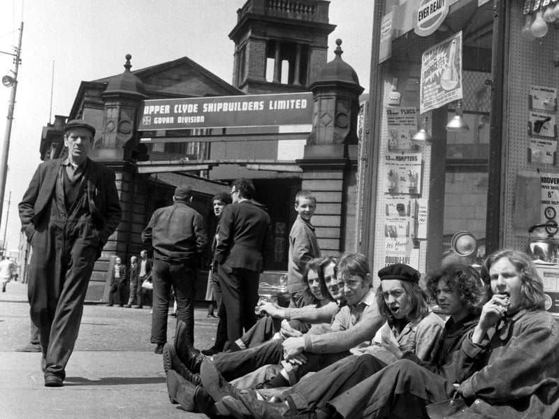 Shipyard workers eat their lunch in the sunshine outside the gates of the Govan division of the Upper Clyde Shipbuilders in June 1971.
