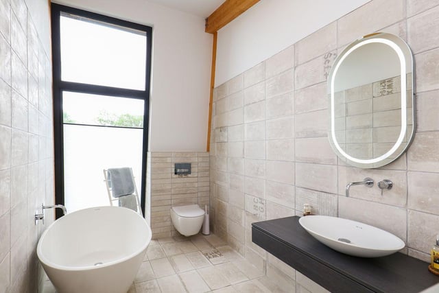 The stand alone bath, subtle tiled finish and generous window help make this bathroom light and airy.