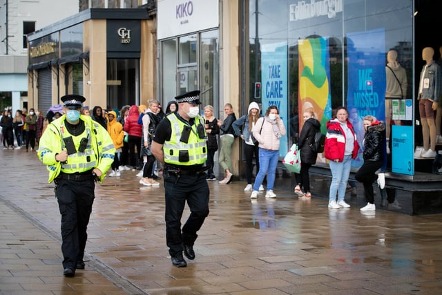 Police patrol alongside the queue outside the Primark store.